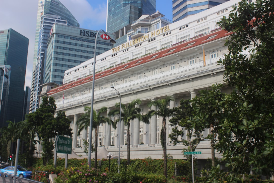 The Fullerton Hotel colonial building with HSBC tower in Singapore's downtown financial district.