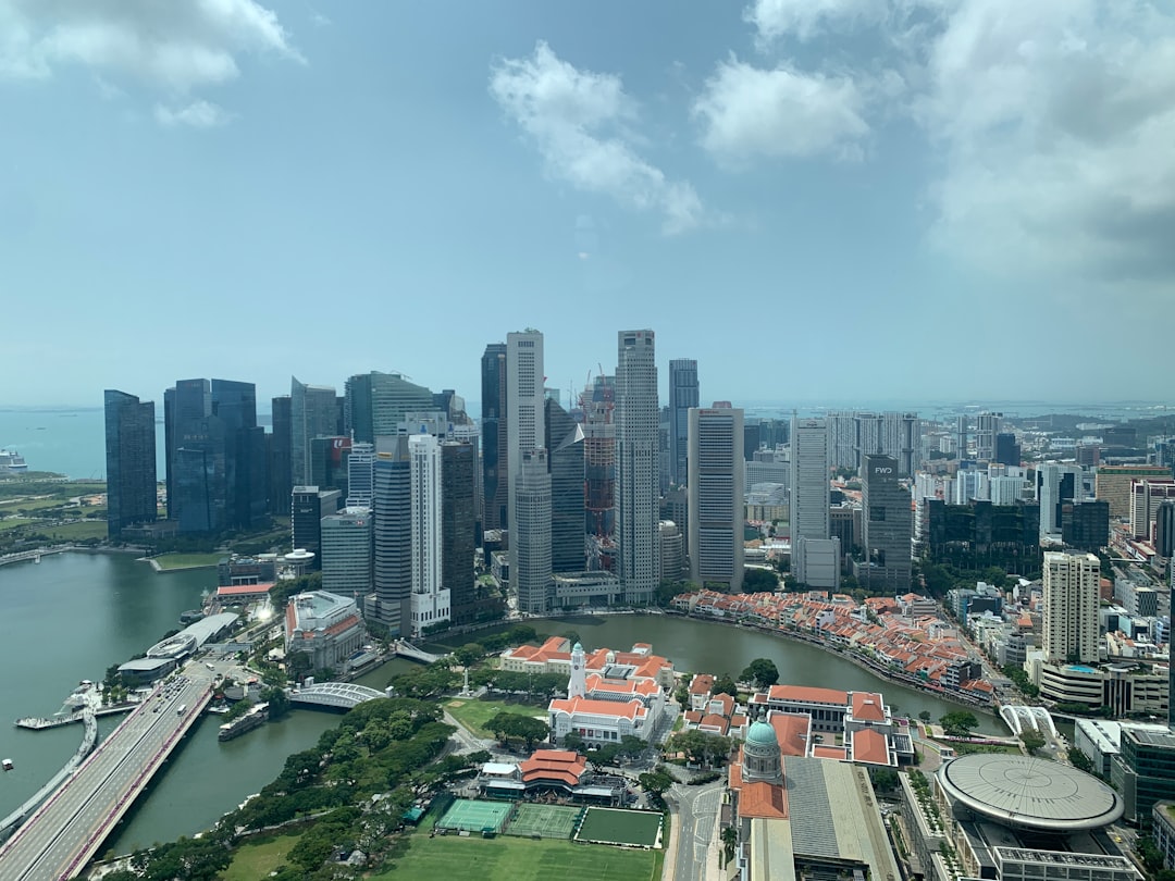 Aerial view of Singapore's downtown skyline with modern skyscrapers, waterfront, and historic temples