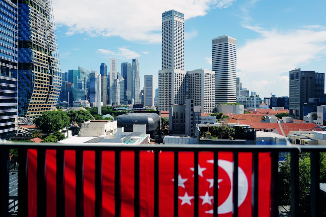 Singapore skyline with skyscrapers viewed from a balcony displaying the national flag