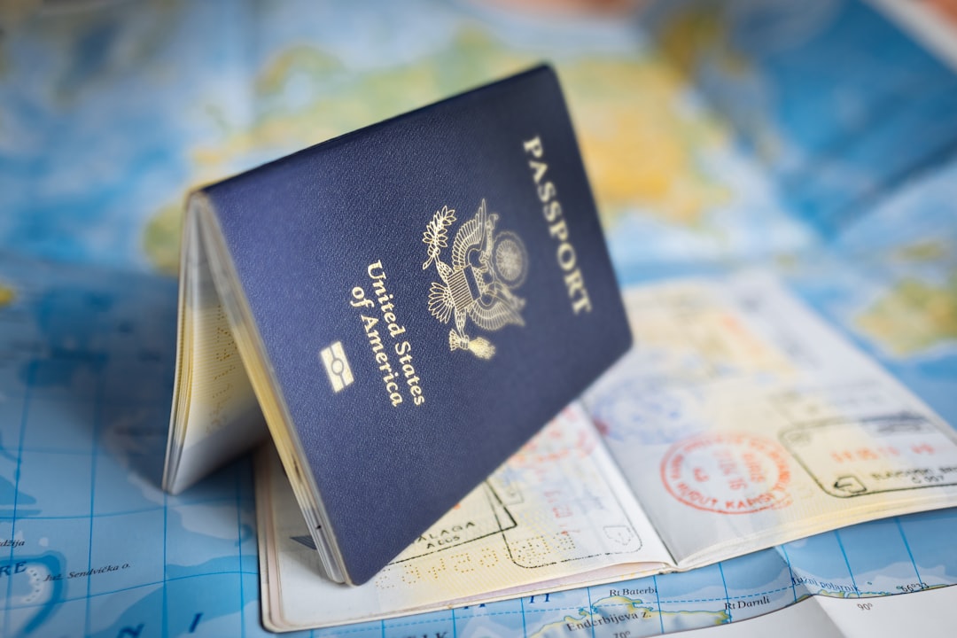 US passport with visa stamps lying on a world map
