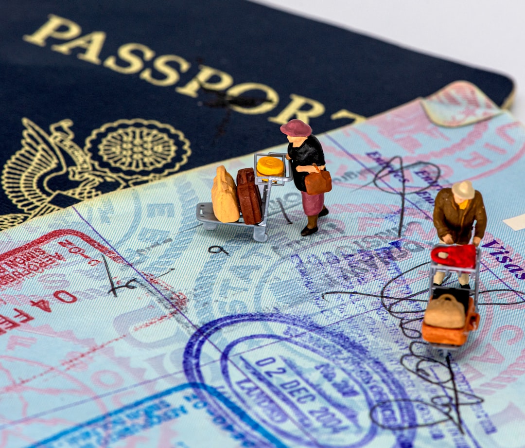 Miniature figures with luggage on passport and visa pages, representing international travel and residency planning