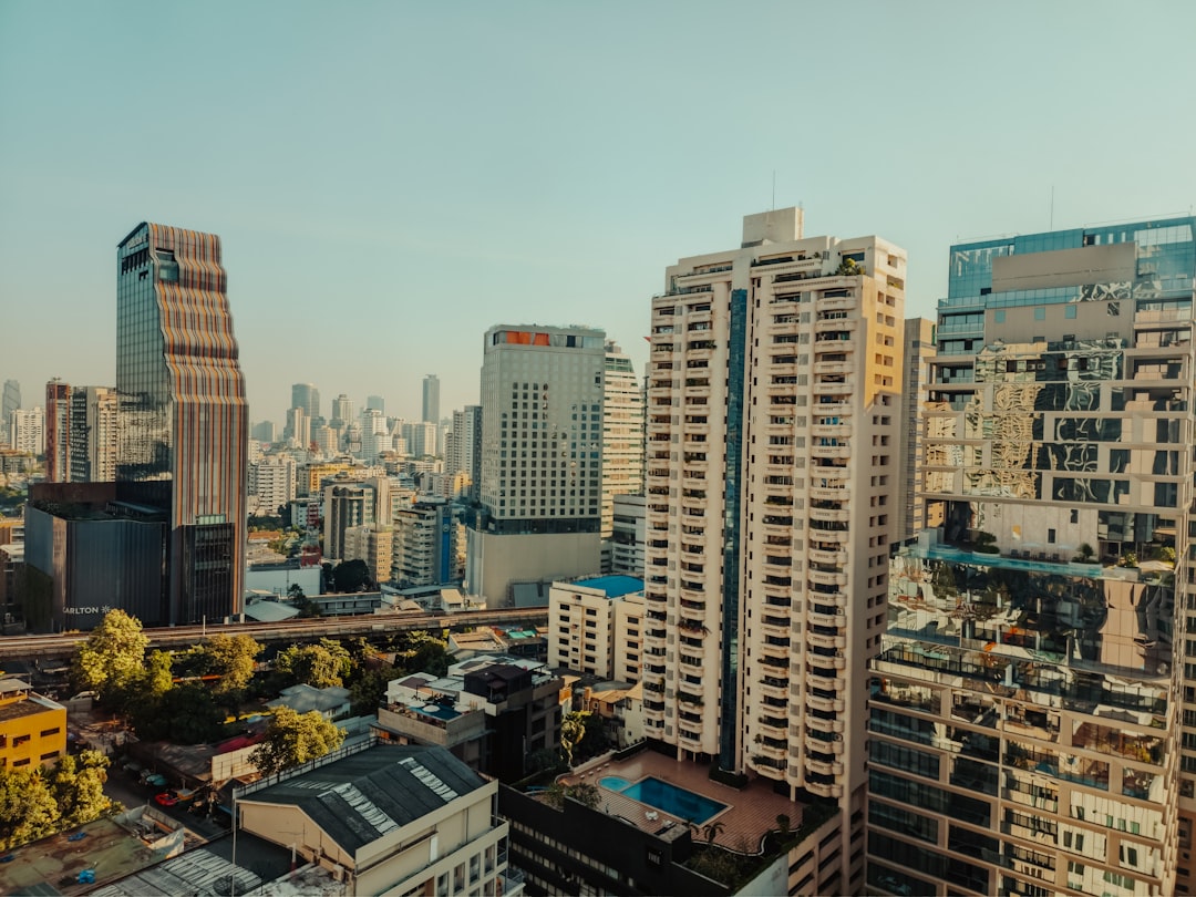 Dense urban cityscape with high-rise residential and commercial buildings under clear blue sky
